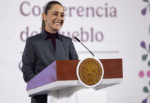 President Sheinbaum stands behind a podium at her morning press conference