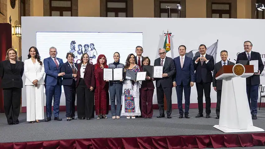 Sheinbaum, Ebrard and more than a dozen Mexican governors stand on stage at a press conference displaying signed letters of intent for the new economic development hubs