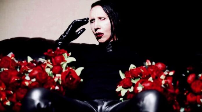 Man with face makeup holding flowers