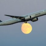 jet flying in front of moon