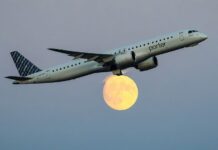 jet flying in front of moon