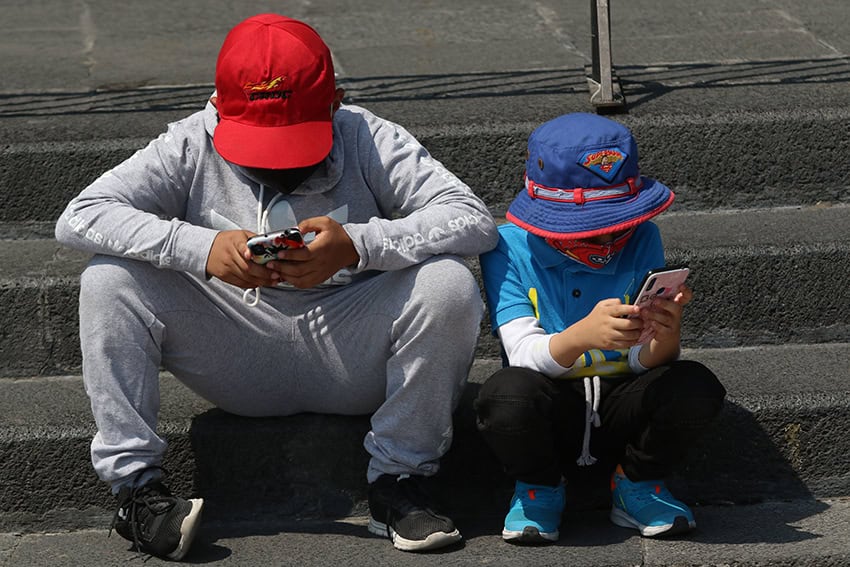Two children (kids) utilizing cellphones