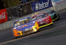 A nascar car races down a track