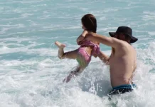 Father and daughter play in surf