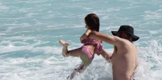 Father and daughter play in surf