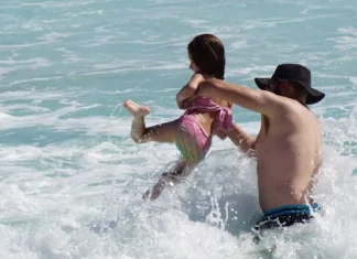 Father and daughter play in surf