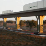 A rendering shows cargo containers moving along an automated freight corridor guideway above a highway