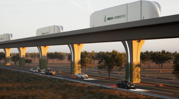 A rendering shows cargo containers moving along an automated freight corridor guideway above a highway