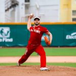 A professional Mexican Baseball League pitcher on the pitching mound, about to pitch a ball during a game in a stadium. He is wearing a El Aguila de Veracruz team uniform.