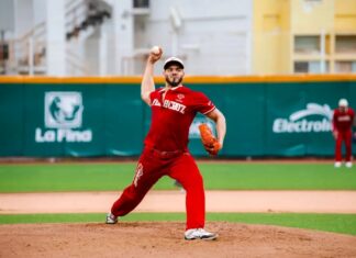 A professional Mexican Baseball League pitcher on the pitching mound, about to pitch a ball during a game in a stadium. He is wearing a El Aguila de Veracruz team uniform.