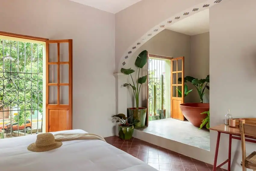 Hotel room with mirror on wall and open balcony door