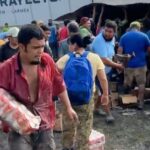 crowd carrying away beer cartons