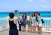 Several tourists having their photo taken by the sea