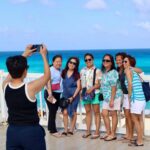 Several tourists having their photo taken by the sea