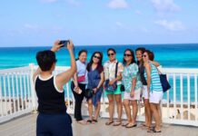 Several tourists having their photo taken by the sea
