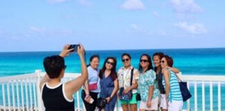 Several tourists having their photo taken by the sea