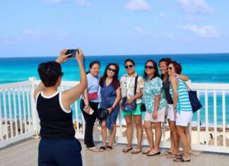Several tourists having their photo taken by the sea
