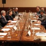 men in suits seated around a conference table at G7