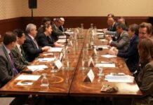 men in suits seated around a conference table at G7