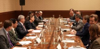 men in suits seated around a conference table at G7
