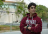 A young Mexican student wears a harvard sweatshirt
