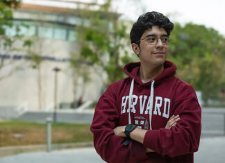 A young Mexican student wears a harvard sweatshirt