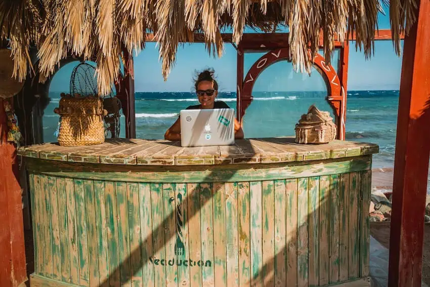 A digital nomad working on a beach