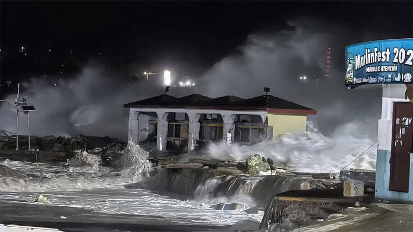 Heavy waves hit a rocky urban coastline at night in Oaxaca