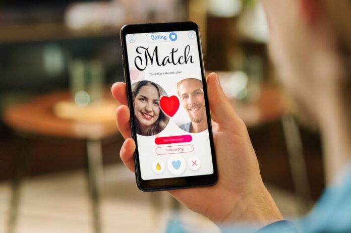 A hand holds a phone showing a dating app match screen