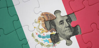 A United States dollar bill peeks out from behind a Mexican flag puzzle