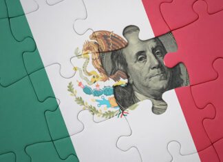 A United States dollar bill peeks out from behind a Mexican flag puzzle