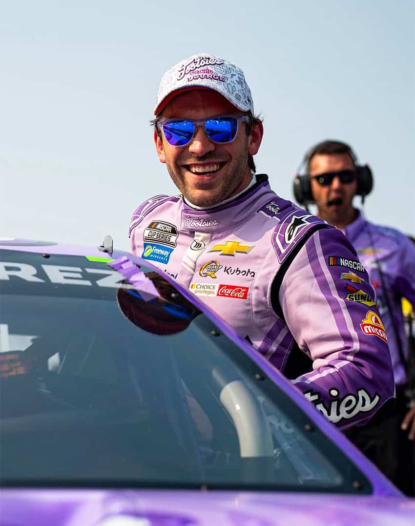 A Nascar racer hangs out of his car for a photo