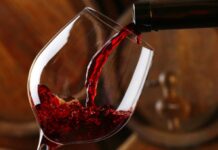 Red wine pours into a glass