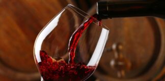 Red wine pours into a glass