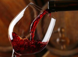 Red wine pours into a glass