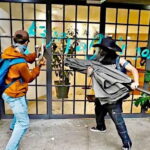 anti-gentrification protesters in Mexico City smash a window