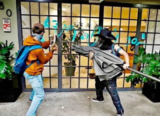 anti-gentrification protesters in Mexico City smash a window