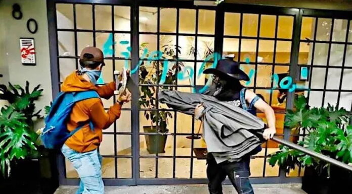 anti-gentrification protesters in Mexico City smash a window