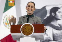 President Sheinbaum smiles from the podium of her morning press conference
