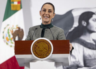 President Sheinbaum smiles from the podium of her morning press conference