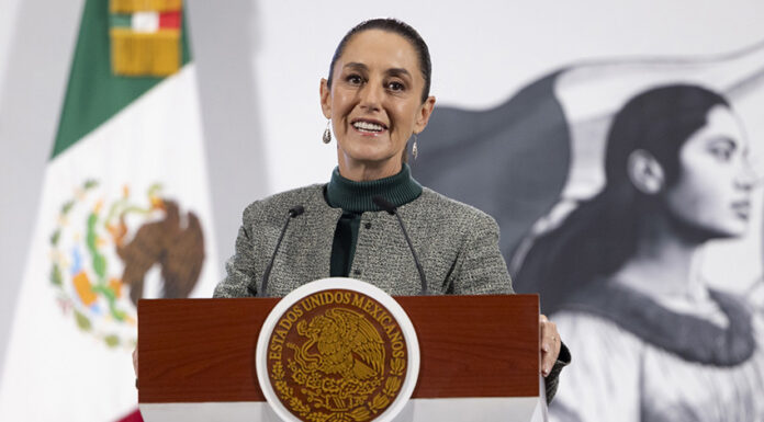 President Sheinbaum smiles from the podium of her morning press conference