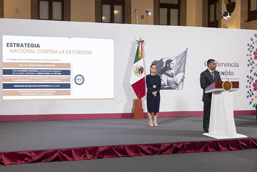 President Sheinbaum looks on as Security Minister García Harfuch shares a presentation about the national strategy against extortion at a press conference