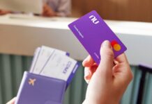 A close up shows a hand with a Nu credit card