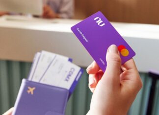 A close up shows a hand with a Nu credit card
