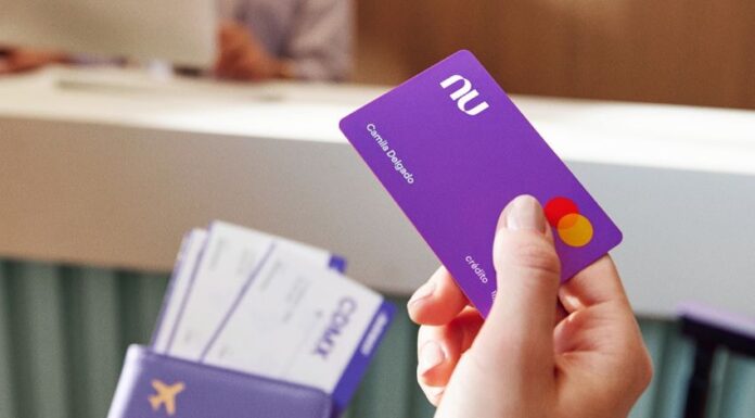 A close up shows a hand with a Nu credit card