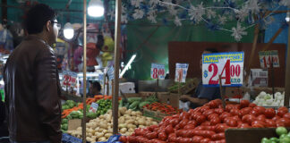 A man looks at produce in a Mexican market