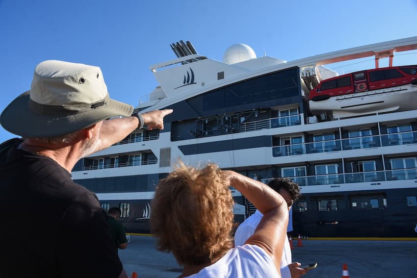 mand and woman pointing at a cruise ship