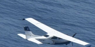 A small plane flies over the ocean