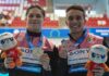 two swimmers holding medals
