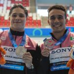 two swimmers holding medals